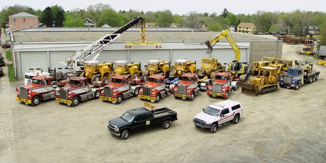Cranes, excavators and heavy haul tractors lined up and ready for a rigging job